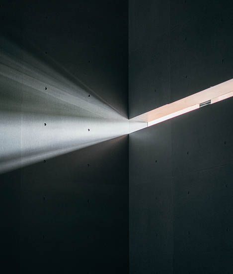 Light protruding through into an empty grey space 