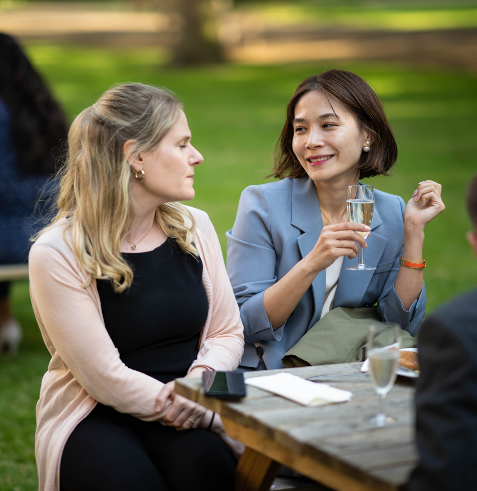 Two women smiling whilst engaged in a conversation 